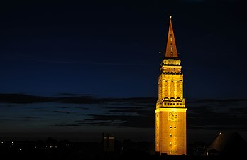 Vista noturna da Torre da prefeitura de Kiel, Alemanha. Seguindo a tradição de construção de prefeituras representativas, o edifício possui torre própria. Ela se ergue de um edifício de conexão entre dois pátios internos sendo projetada no estilo de uma torre sineira como o campanário de São Marcos em Veneza. A torre de Kiel, com 106 m de altura pode ser visitada como parte de uma visita guiada. Um elevador sobe ao nível de observação a uma altura de 67 m, que se estende ao redor da torre e permite vistas de longo alcance sobre: o centro da cidade e o porto no nordeste, a margem leste do fiorde de Kiel, a estação ferroviária principal e a ponta do porto no sul, e os assentamentos ocidentais até o distrito de Mettenhof. (definição 3 961 × 2 557)