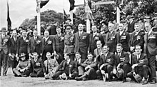 Une photo de groupe en noir et blanc d'hommes portant des costumes et des médailles.