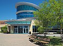 A stone-and-glass building with a cylindrical glass rotunda