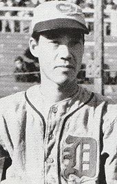 Michio Nishizawa wearing a light baseball uniform with an ornate "D" over his left breast and a light baseball cap