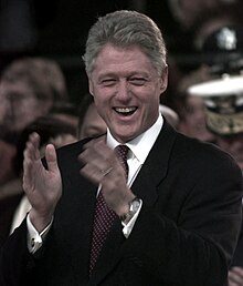 President Bill Clinton applauds as he watches the Presidential Inaugural Parade from the reviewing stand during the 1997 presidential inaugural ceremony