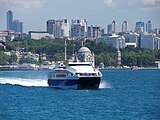 A catamaran Seabus on the Bosphorus, with the skyscrapers of Levent business district in the background. Istanbul Sapphire is the first skyscraper on the left.