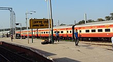 Long orange-and-white passenger train in a station