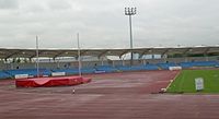 The Manchester Regional Arena, showing the running track, high jump apparatus and an empty stand.