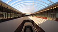 Interior photograph of the Marin County Civic Center. The skylit, two-story atrium has plantings, few sharp corners, and lots of reds and pinks.