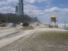 Sand that has been blown in from the beach due to gale-force wind is being removed from Main Beach Parade on 29 January 2013.