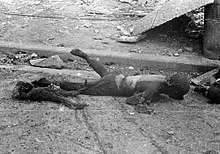 Black and white photograph of two burnt human bodies