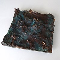 Boat in moving sea, bronze relief by Ingo Kühl, 2019