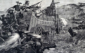 A southern African colonial battle scene. A small number of white soldiers wearing slouch hats use the crates on their wagons as cover and shoot at an apparently vast number of black warriors.