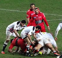 Ruck opposant des joueurs du Stade français, en blanc, à des joueurs de Toulon, en rouge. Habana et Gorgodze, qui ne participent pas au ruck, surveillent le débat.