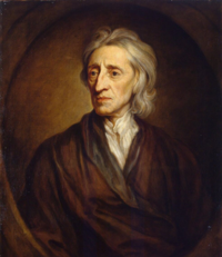 Half-length portrait of a man with a shock of neck-length white hair who is wearing a loose brown robe and white shirt.
