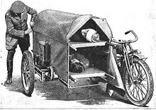 Securing the canvas cover on a motorcycle sidecar containing two patients.
