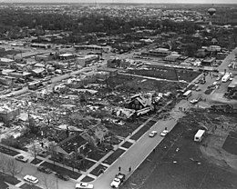 Aerial view of several blocks of home foundations stripped bare with debris launched everywhere
