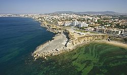 Pedra do Sal e Centro de Interpretação Ambiental, na costa de São Pedro do Estoril, no primeiro plano da imagem.