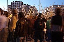 Vue d'une foule de dos au crépuscule.