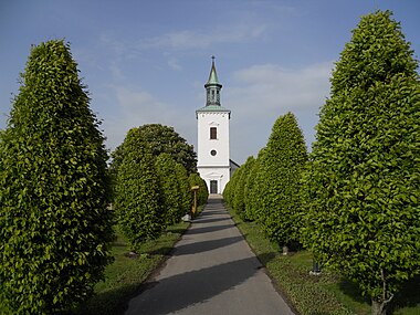 Träslövs kyrka med den allé som leder fram till porten.