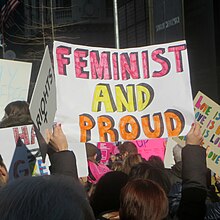 Protest sign in a crowd which says 'feminist and proud'