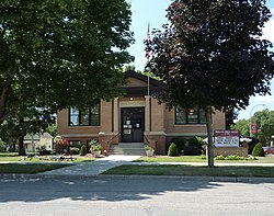 A small, one-story brick building on a raised basement