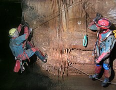 Franchissement d'une vire au-dessus d'un lac dans la grotte de la Cabane à Saint Paul des Fonts, Saint-Jean-et-Saint-Paul, Aveyron, France.