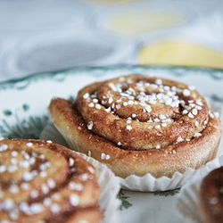 sokeroituja kanelikierrepullia paperikääreessä lautasella