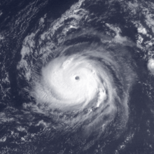 A powerful hurricane over the central Atlantic Ocean to the south-southeast of Bermuda, with a tightly-wound cloud pattern around a clear eye