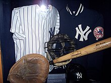 A catcher's mitt, "NY" shirts, catcher's mask, and bat.