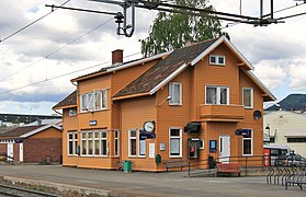 Foto eines orange gestrichenen hölzernen Bahnhofsgebäudes