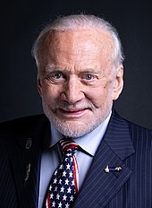 Portrait en couleur d'Aldrin en costume avec une cravate aux couleurs du drapeau américain.