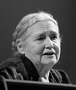 Portrait photographique en noir et blanc d'une femme d'un certain âge vue de trois-quarts droit, la bouche légèrement entrouverte.