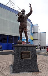 A statue of a footballer lifting a trophy