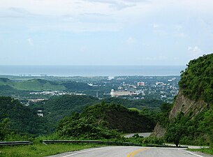 Heading south in Barrio Maragüez, Ponce, with the city of Ponce and the Río Portugués channel in the background and the Caribbean Sea in the far background