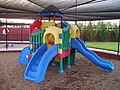 Combination playground structure for small children; slides, climbers (stairs in this case), playhouse