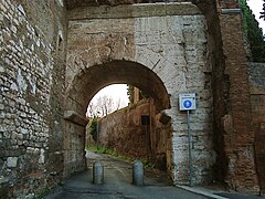 Photographie en couleurs d'une arche en pierre au-dessus d'une rue.