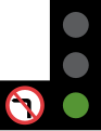 A standard traffic light with a supplemental 'no left turn' sign attached