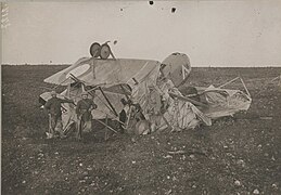 Photo noir et blanc de militaires posant devant une carcasse d'avion.