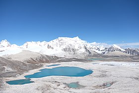 Vue du versant ouest du Gangkhar Puensum depuis le Gophu La, avec à gauche du sommet la longue arête horizontale qui mène à son sommet secondaire, le Liankang Kangri (7 535 m).