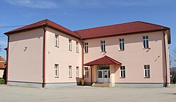 A light coloured angled two story building