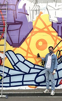 artist Misha Most standing near his new mural