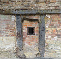 The hearth of the furnace, with the remains of the last failed firing showing as the yellowish mass at the bottom. Of interest are the hand impressions cast into the uprights of the hearth. A hole has been made to allow a view of the now emptied inside of the furnace