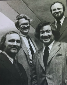 Screenshot of a digitized ROMA brochure, featuring a photograph of James Amis, Robert Mountjoy, George Rockrise, and Robert A. Odermatt smiling at the camera.