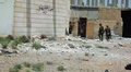 SDF fighters walk through a destroyed area in the suburbs of Raqqa, 13 June 2017