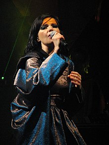 Image d'une chanteuse brune habillée d'une robe bleu gris