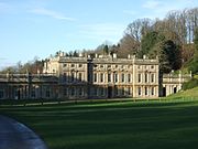 Vue générale d'un vaste bâtiment encadré de deux légères avancées, avec deux ailes basses surmontées d'une terrasse.