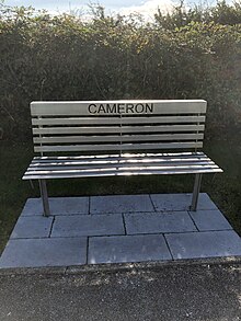 A metal bench with the name "Cameron" cut through the back.