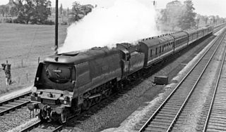 Side-and-front view of a large 4-6-2 steam locomotive with a tender, hauling a passenger train. The locomotive boiler is hidden by a casing of flat metal side sheets.