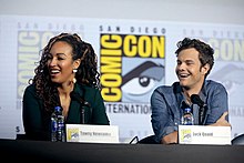 Tawny Newsome and Jack Quaid at a table on stage at Comic-Con