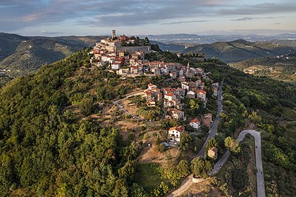 Vista aérea da vila croata de Motovun, no centro da Ístria. Nos tempos antigos, tanto os celtas quanto os ilírios construíram suas fortalezas no local da atual Motovun. O nome da vila também é de origem celta, derivado de Montona, que significa “uma cidade nas colinas”. A população da aldeia propriamente dita é de 531 habitantes, com um total de 983 residentes no concelho (2001); 192 dos residentes falam italiano como língua materna. A Parenzana, uma ferrovia de bitola estreita que ia de Trieste a Poreč/Parenzo entre 1902 e 1935, passava abaixo da vila. (definição 5 460 × 3 640)