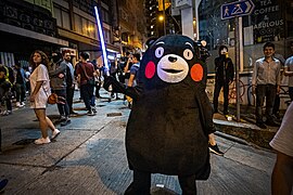 A protester, cosplaying as Kumamon swinging a toy lightsaber, Halloween 2019