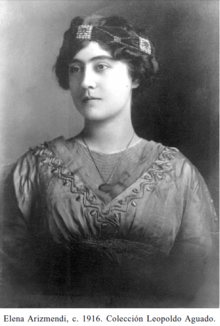 Black and white portrait of a woman wearing an Empire-waist dress with a scoop-necked under blouse and a v-shaped neckline on the over blouse which is heavily-decorated with trapunto quilting. Her hair is swept into a bun and adorned with a turban encircled at its base by a beaded-band.