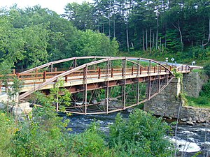 View of the bridge from the north, crossing a deep gorge, with curving trusses over and under